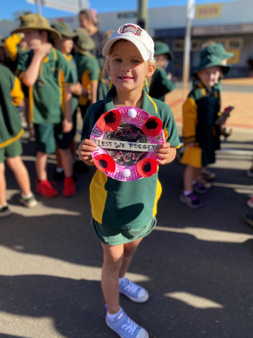 young girl holding anzac wreath