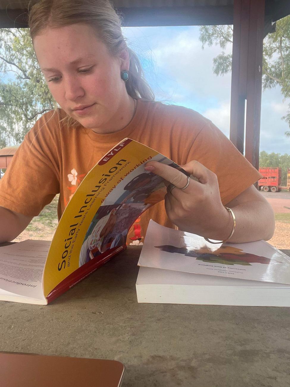 girl looking through book 