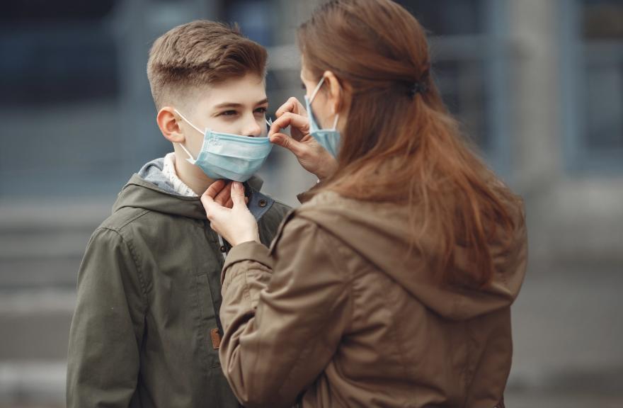 Adult adjusting child’s mask. 