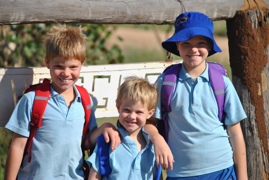 A picture of three school children wearing blue