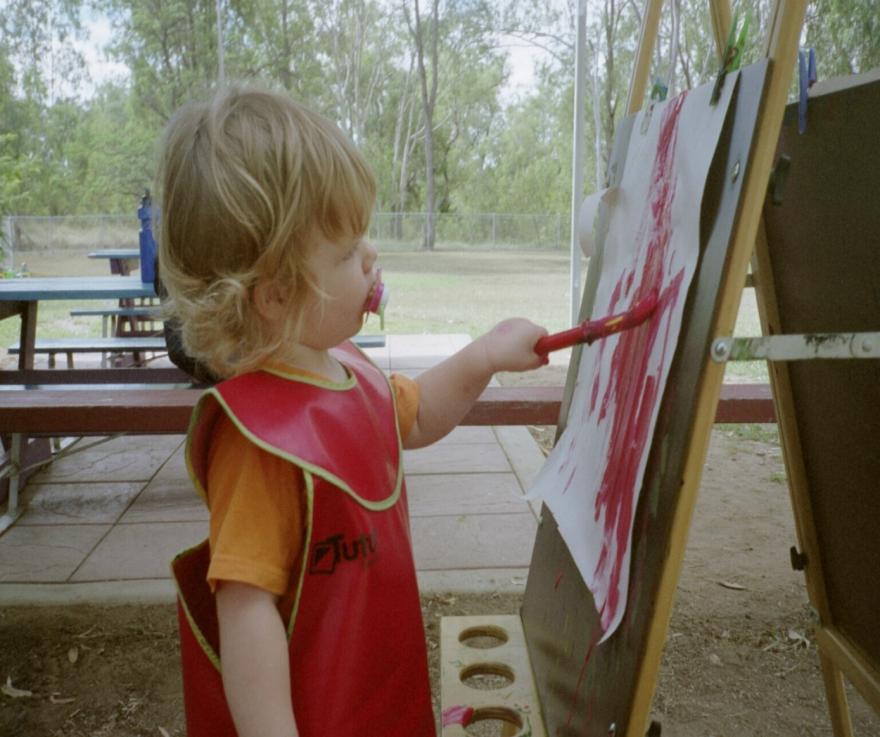 little girl painting at easel