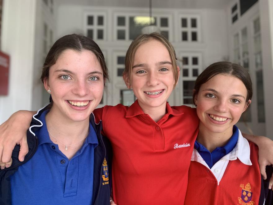 Three girls on the front steps of a boarding house