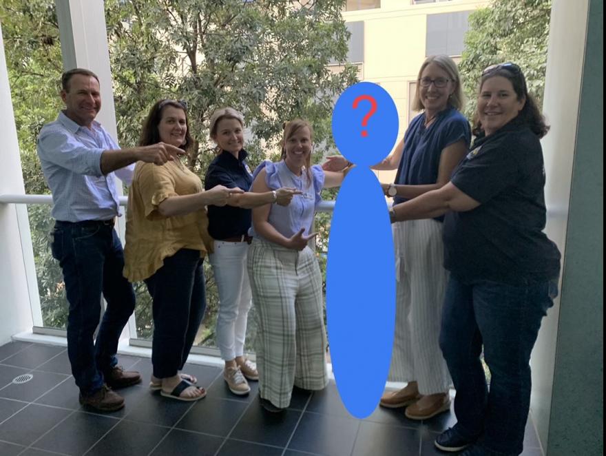 A picture of a group of state council pointing at a blue blob.