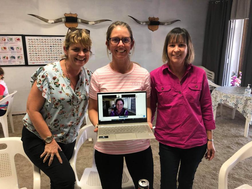 picture of 3 ladies middle holding laptop