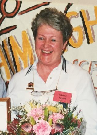 picture of Elaine carrying flowers wearing a white polo