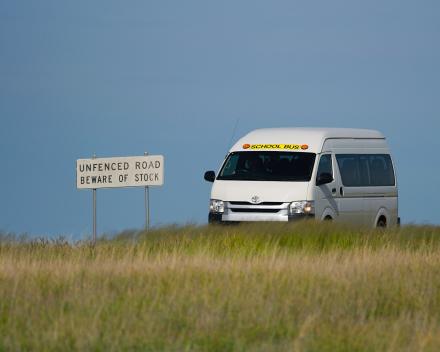 A picture of a school bus on a country road