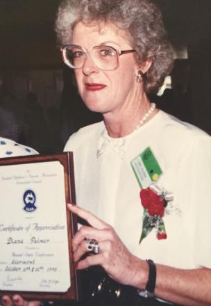 picture of Diana wearing a white blouse and red carnation