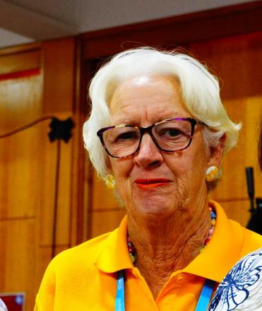 lady with black glasses wearing yellow polo shirt