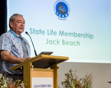 A picture of Jack Beach accepting his State Life membership standing at the lecturen