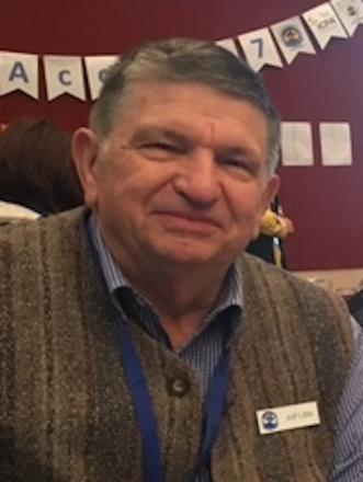 A picture of Jeff Little wearing a vest and smiling at the camera