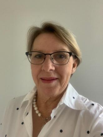 photo of Judy wearing glasses and white shirt with black spots