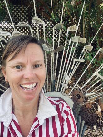 A picture of Melissa Iland in a red and white stipe shirt in front of a metal peacock with golf club tail.