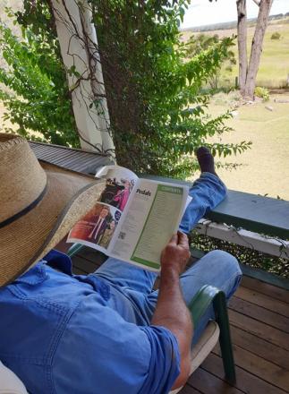 man on verandah reading pedals