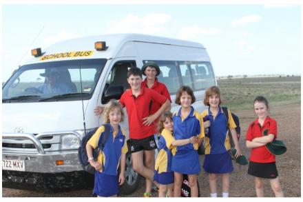 children waiting in front of school bus