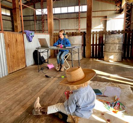 children doing schoolwork in woolshed